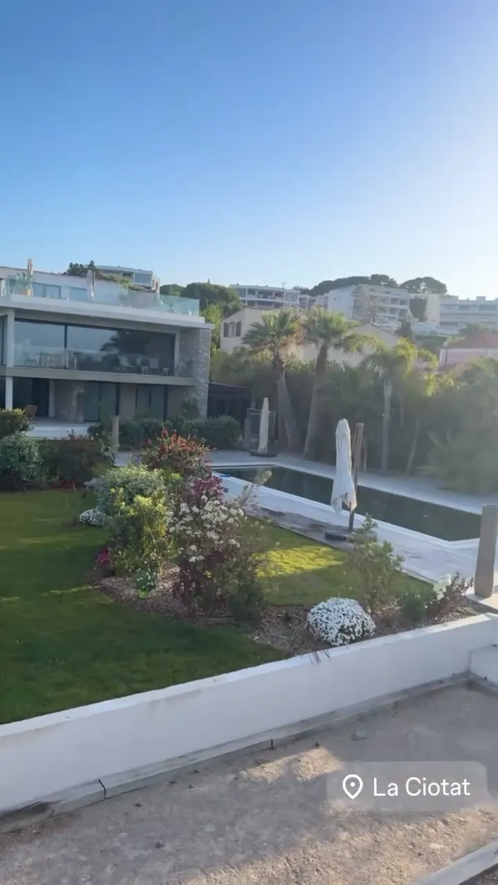 Jardin de bord de mer à La Ciotat : pelouse, massifs fleuris, palmiers et piscine